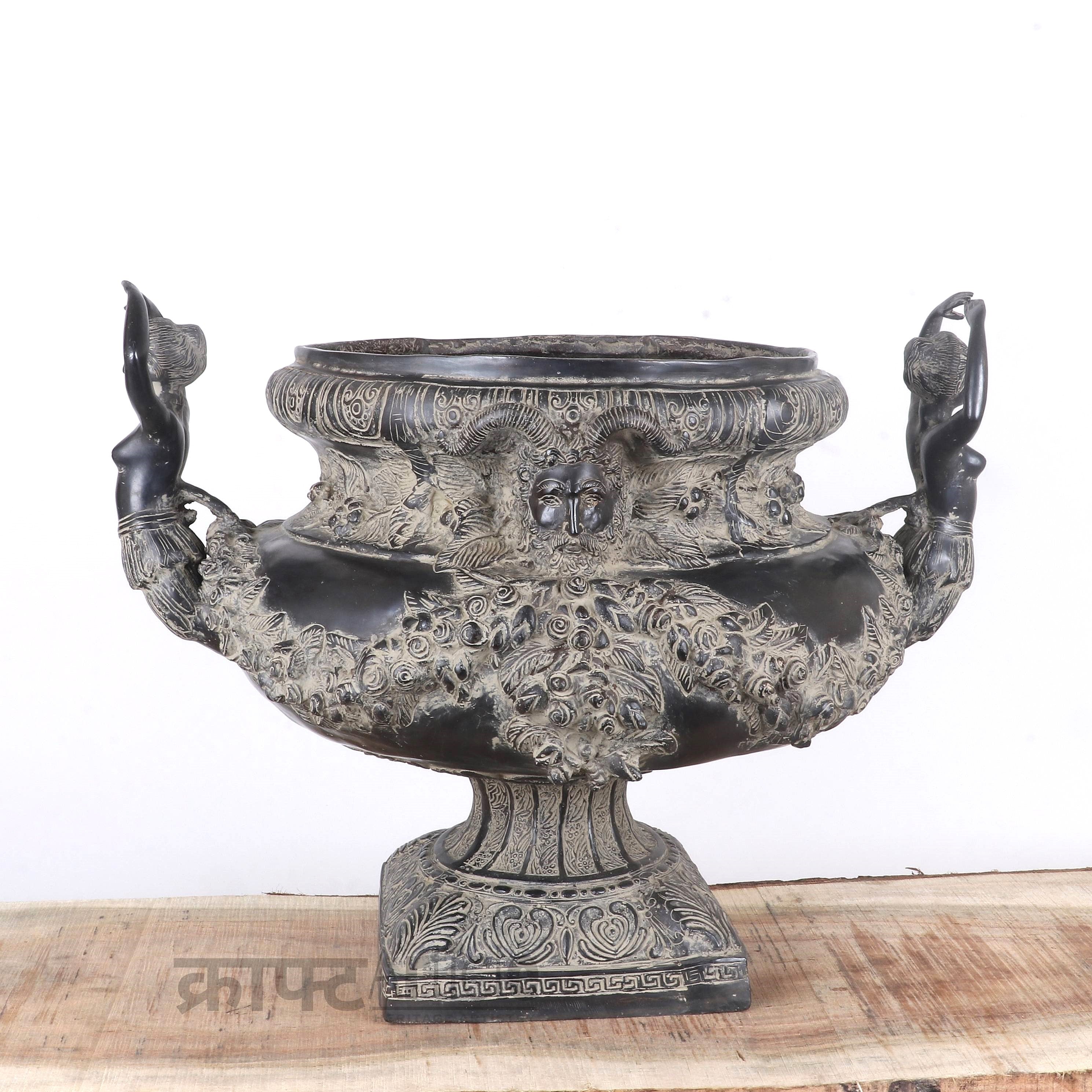 Decorative urn with intricate designs on a wooden surface