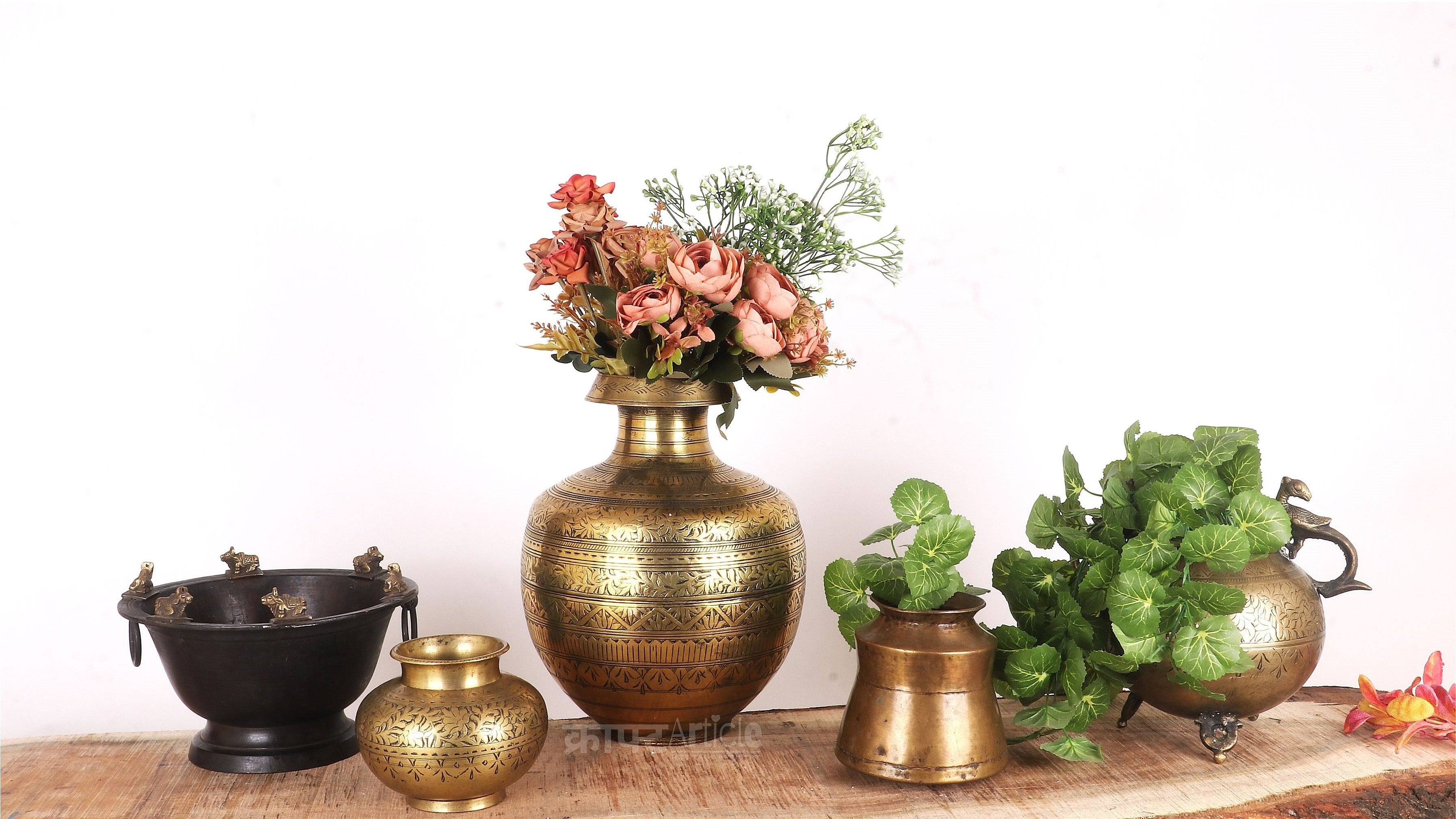 Collection of decorative vases and bowls on a wooden surface with a white background